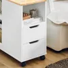 A close-up view of a white rolling cabinet with a wooden top, placed next to a white sofa. Náhľad obrázku produktu