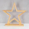 A wooden star-shaped LED lamp on a white surface against a gray concrete wall. Produktbild-Vorschau