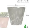 A close-up of a gray planter with a textured, stone-like finish, shown next to a pink planter with a plant. Dimensions and volume are indicated. Produktbild-Vorschau