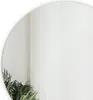 A close-up of a round mirror reflecting sheer white curtains and a plant. Náhled obrázku produktu