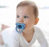 A baby is lying on its stomach with a pacifier in its mouth. Produktbild-Vorschau