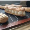 A close-up shot of eclairs filled with cream, placed on a baking mat. Podgląd zdjęcia produktu