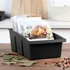 A black spice organizer filled with spice packets sits on a wooden surface, with bay leaves and peppercorns scattered around. Náhľad obrázku produktu