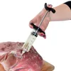 A hand is using a marinade injector to inject liquid into a piece of raw meat seasoned with salt and herbs. Náhled obrázku produktu