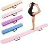 A young gymnast is performing a pose on a pink balance beam, with several other balance beams in different colors stacked behind her. Náhled obrázku produktu