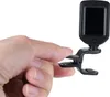 A hand is holding a clip-on digital tuner. Náhled obrázku produktu