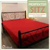 A red fitted sheet is shown on a bed with a black metal headboard. Text overlays highlight product features. Produktbild-Vorschau