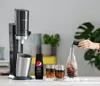 A person is pouring syrup into a bottle of soda water next to a SodaStream machine, Pepsi MAX syrup, and two glasses of soda. Produktbild-Vorschau