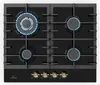 A top-down view of a black gas stovetop with four burners, two of which are lit with blue flames. The stovetop has a black glass surface and a black control panel with four gold knobs. Náhľad obrázku produktu