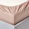A close-up view of a beige fitted sheet on a bed frame. Náhled obrázku produktu