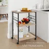 A kitchen serving cart with food and kitchen items, placed in a kitchen or dining area. Náhled obrázku produktu
