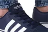 A close-up view of a person wearing dark blue Adidas sneakers. Náhľad obrázku produktu