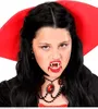A young person dressed as a vampire, showing fake fangs and a necklace. Produktbild-Vorschau