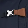 A close-up of a buckle and strap on a dark blue backpack. Podgląd zdjęcia produktu