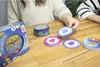 Two people are playing a card game called Wortblitz on a wooden table. The game box and some cards are visible. Produktbild-Vorschau