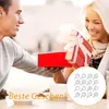 A man gives a woman a gift, and she is happily opening it. A set of coffee stencils is shown in the foreground. Produktbild-Vorschau
