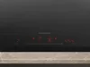A close-up view of the control panel of a black induction hob. Produktbild-Vorschau