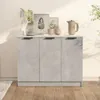 A grey sideboard with three doors is shown in a room with wooden flooring and a light-colored wall. Decorative items like plants, framed pictures, and a jug are placed on top of the sideboard. Anteprima dell’immagine prodotto