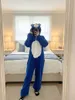 A person wearing a blue bear costume stands in a bedroom in front of a bed. Produktbild-Vorschau