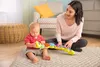 A baby and a woman are sitting on the floor playing with a musical caterpillar toy. Produktbild-Vorschau