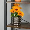 A vase with orange flowers sits on a shelf. Produktbild-Vorschau