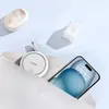 A flat lay of tech accessories including a phone, charger, and wireless earbuds case, arranged on a light blue background. Anteprima dell’immagine prodotto