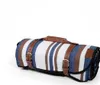 A rolled-up picnic blanket with leather straps and buckles, presented against a white background. Anteprima dell’immagine prodotto