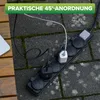 A black power strip with multiple plugs and cables connected, lying on a stone and wood surface. Produktbild-Vorschau