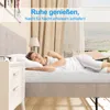 A woman sleeping peacefully on a bed with a mattress and a bedside table. Produktbild-Vorschau