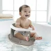 A baby is sitting in a bathtub using a baby bath seat. Produktbild-Vorschau
