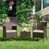 A patio furniture set with two chairs and a small table is set up on a green lawn in front of a house with lush greenery. Produktbild-Vorschau