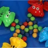 A close-up view of a children's toy with colorful frog characters and small balls. Náhled obrázku produktu