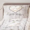 A close-up view of a pillowcase and duvet cover with a rustic, wood-grain pattern and a heart-shaped motif featuring deer silhouettes. Produktbild-Vorschau