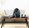 A black and gray vacuum cleaner with accessories is displayed on a wooden table in front of a sofa. Produktbild-Vorschau