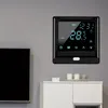 A smart thermostat is mounted on a gray wall above a white cabinet. A large black television is to the left of the thermostat. Náhled obrázku produktu