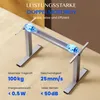 A silver electric standing desk frame with blue glowing motors is shown in a studio setting with a textured background. Produktbild-Vorschau