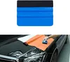 A person is applying an orange vinyl wrap to the hood of a black car using a blue squeegee tool. Produktbild-Vorschau