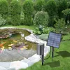 A solar-powered pond aerator with a solar panel is placed on the grassy bank of a pond with koi fish. Náhled obrázku produktu
