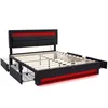 A black upholstered bed frame with red LED lighting, shown from a three-quarter angle with the mattress support slats visible and two storage drawers pulled out. Náhľad obrázku produktu