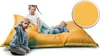Three children are playing on a large yellow beanbag chair. Produktbild-Vorschau