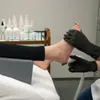 A person's foot is being treated with a pedicure device, with various cosmetic products in the background. Anteprima dell’immagine prodotto