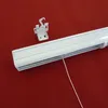 A white blind mechanism and a mounting bracket are displayed on a red background. Produktbild-Vorschau