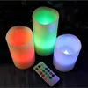 Three LED candles of different colors and a remote control are displayed on a dark surface. Produktbild-Vorschau