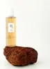 A bottle of cleansing oil sits on a rock. Anteprima dell’immagine prodotto