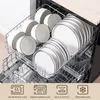 A dishwasher rack filled with white ceramic plates and bowls with black trim. Produktbild-Vorschau