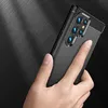 A hand holding a black phone case with a carbon fiber texture. Produktbild-Vorschau