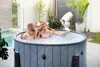 A couple relaxing in an inflatable hot tub in an outdoor patio setting. Náhled obrázku produktu