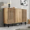 A modern sideboard with slatted doors is placed against a concrete wall, with a lamp and decorative items on top. Anteprima dell’immagine prodotto