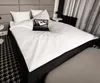 A neatly made bed with a laptop on top. Produktbild-Vorschau