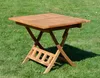A wooden folding table is set up on a grassy lawn. Produktbild-Vorschau